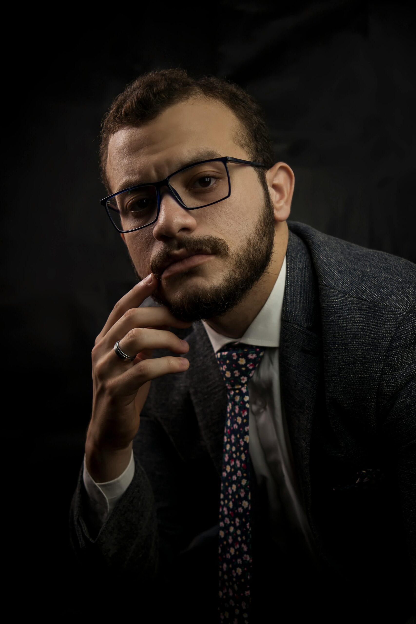 Professional corporate portrait of a bearded man in suit and eyeglasses.