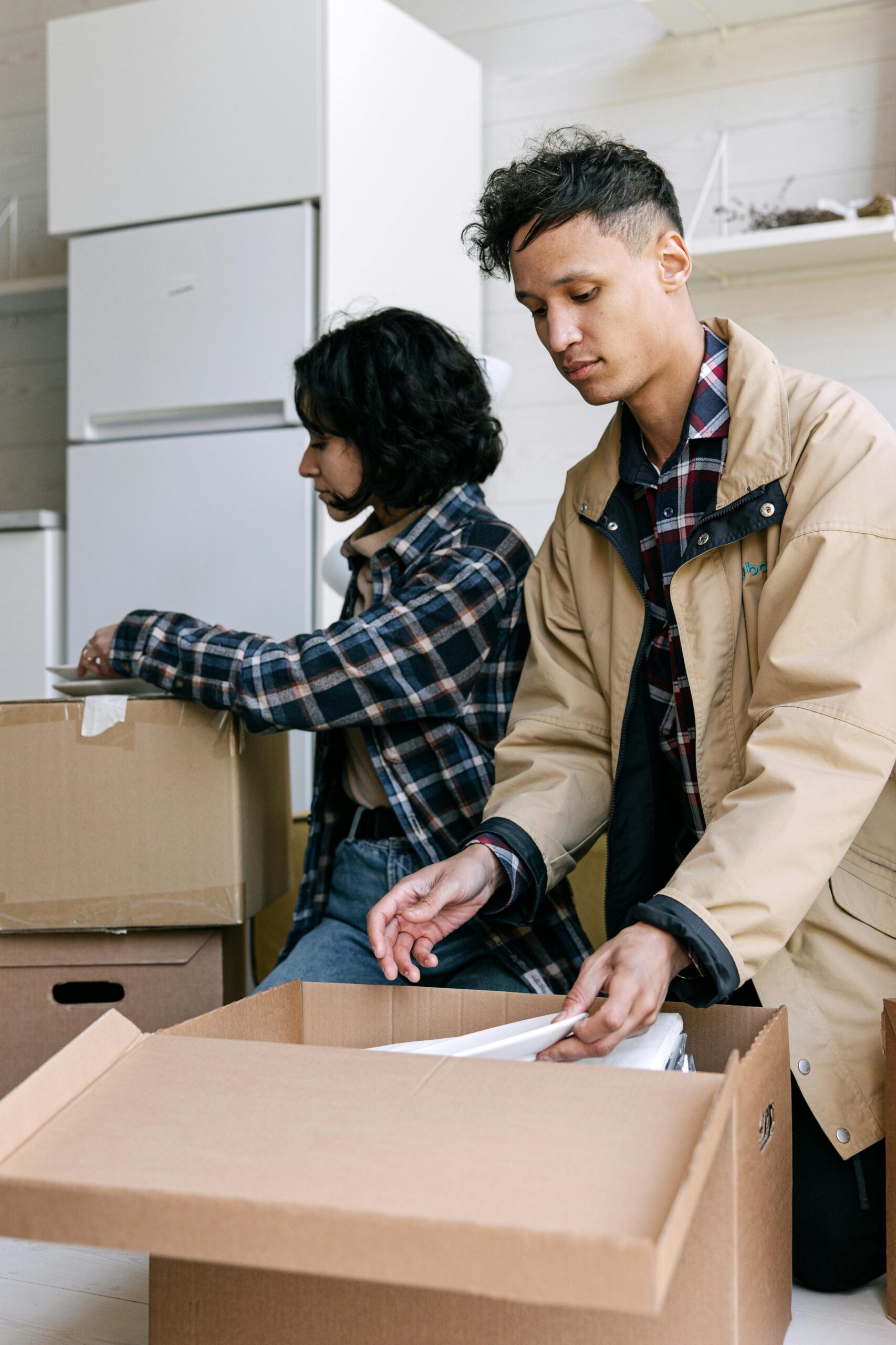 Young couple unpacking boxes in their new modern apartment.